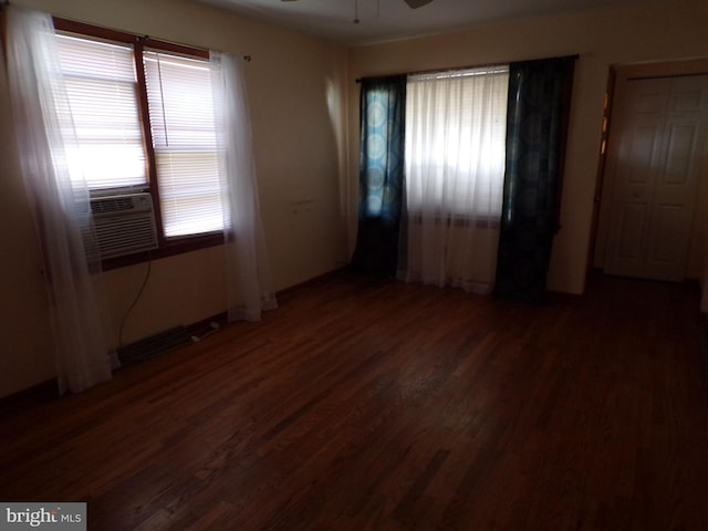 unfurnished room with cooling unit, ceiling fan, and dark hardwood / wood-style flooring