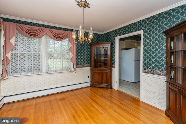 unfurnished dining area with baseboard heating, ornamental molding, a chandelier, and light hardwood / wood-style floors