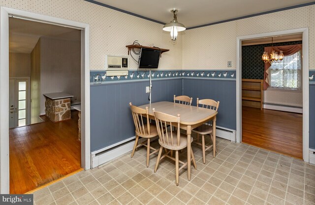 dining area with baseboard heating, a notable chandelier, and light hardwood / wood-style floors