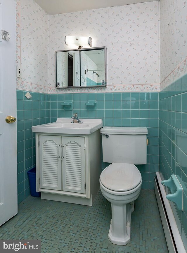 bathroom featuring vanity, a baseboard radiator, tile patterned flooring, tile walls, and toilet