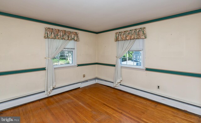 empty room featuring a wealth of natural light and hardwood / wood-style floors