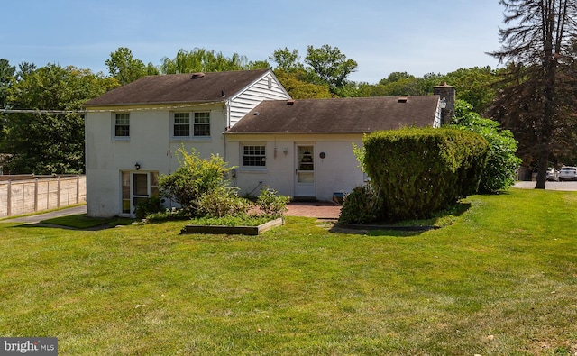 back of house featuring a lawn