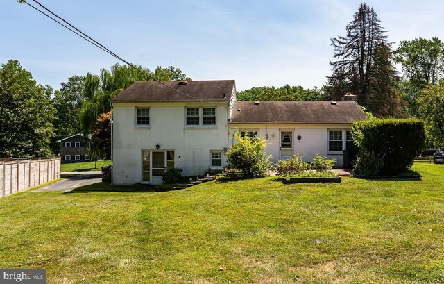 rear view of house featuring a yard