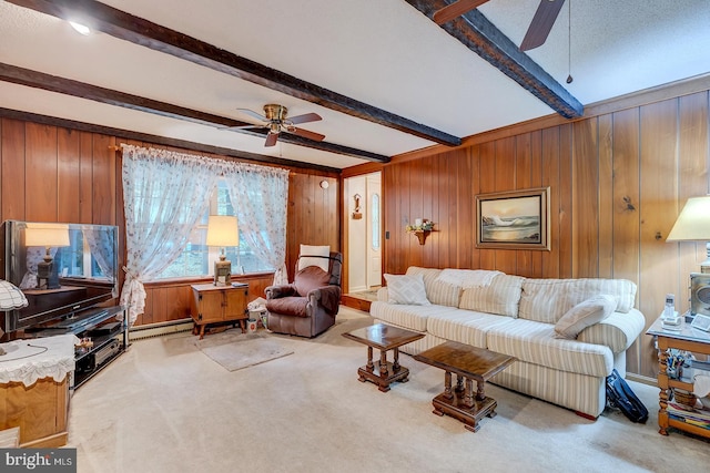 carpeted living room with wood walls, beam ceiling, ceiling fan, and baseboard heating