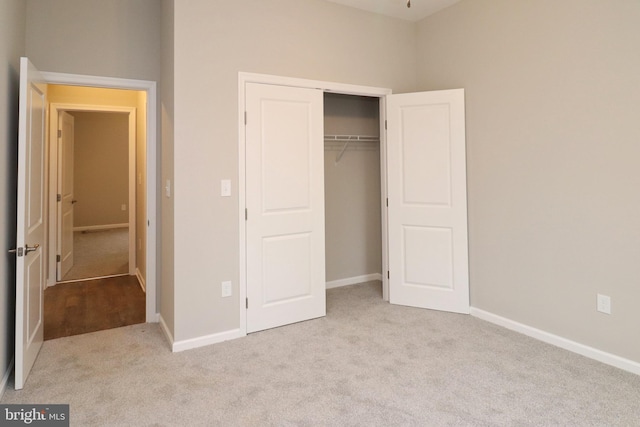 unfurnished bedroom with a closet, carpet flooring, and baseboards