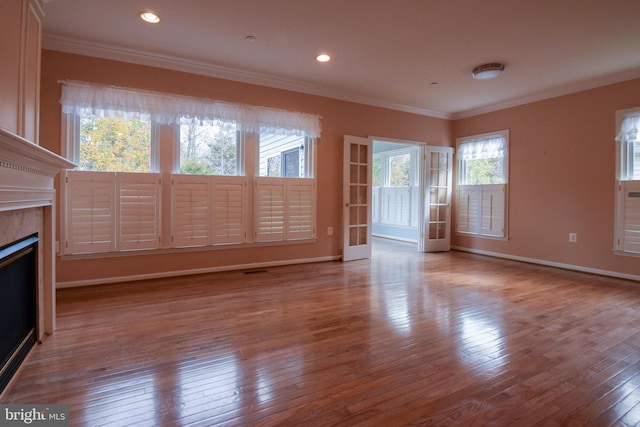 unfurnished living room with ornamental molding and light hardwood / wood-style flooring