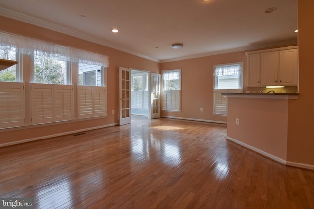 unfurnished living room featuring crown molding and light hardwood / wood-style flooring