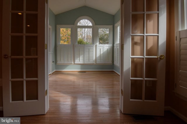 empty room with wood-type flooring and lofted ceiling