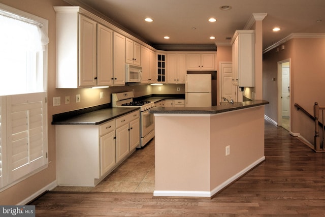 kitchen featuring hardwood / wood-style flooring, white cabinets, white appliances, and crown molding