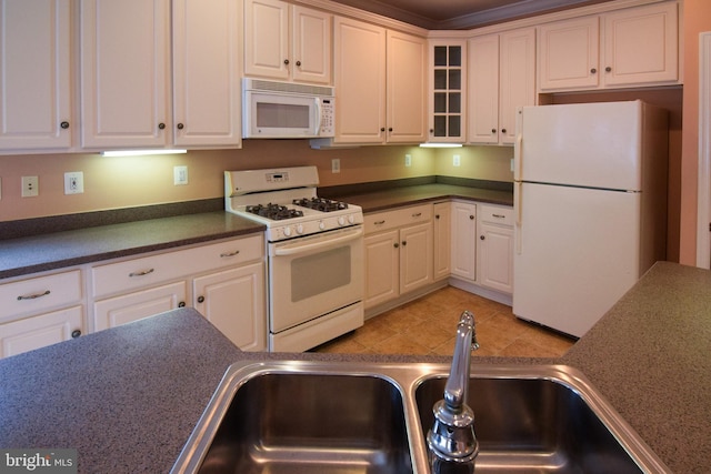 kitchen with sink, white cabinets, white appliances, and light tile patterned floors