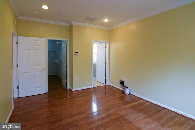 empty room with crown molding and dark wood-type flooring