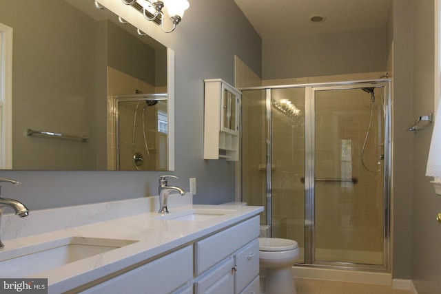 bathroom featuring vanity, toilet, and a shower with shower door