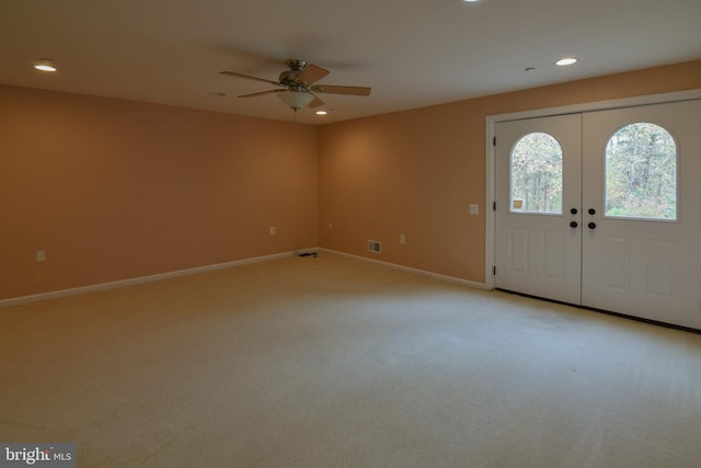 carpeted entryway with ceiling fan and french doors