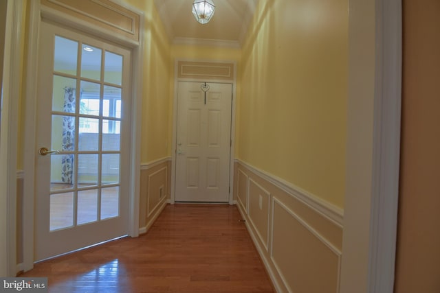 doorway to outside with crown molding and light hardwood / wood-style floors