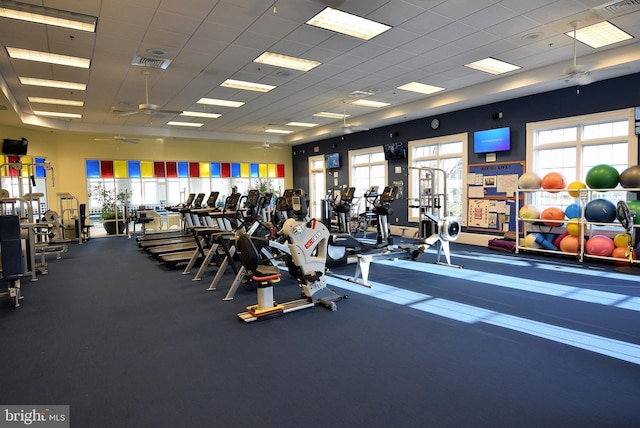 gym featuring a drop ceiling and ceiling fan