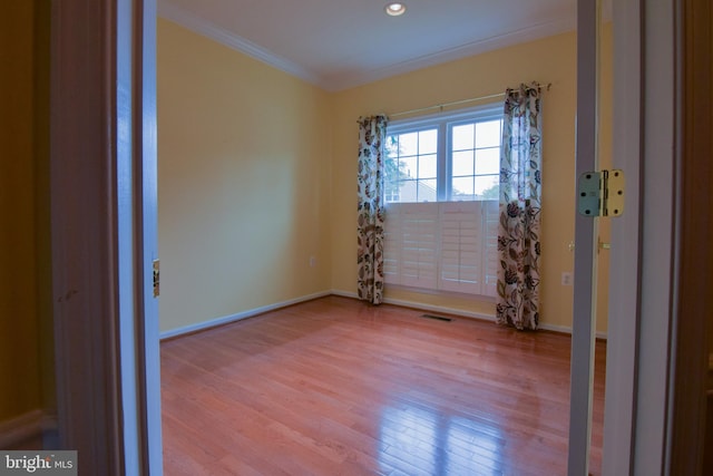 unfurnished room featuring light hardwood / wood-style flooring and ornamental molding