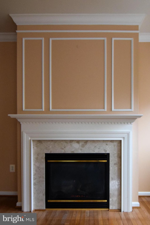 interior details with a fireplace, wood-type flooring, and ornamental molding