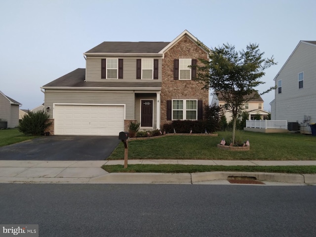 traditional-style home featuring aphalt driveway, central AC unit, a front yard, a garage, and stone siding