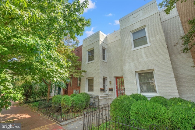 townhome / multi-family property featuring brick siding and fence