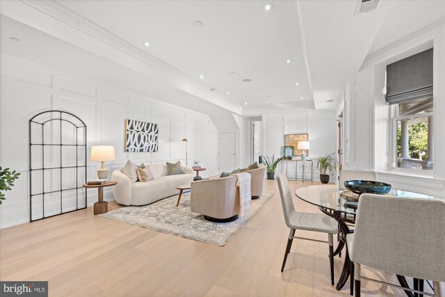 living room featuring light wood-type flooring and crown molding