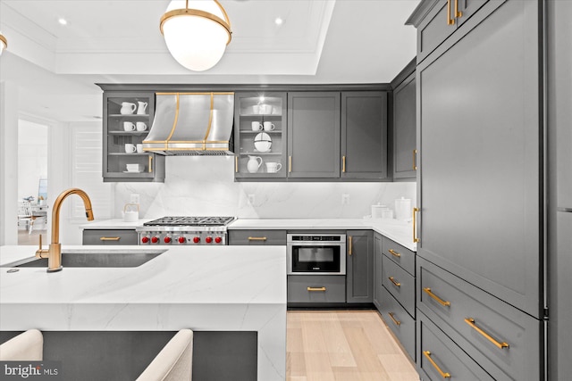 kitchen with gray cabinets, appliances with stainless steel finishes, sink, and premium range hood