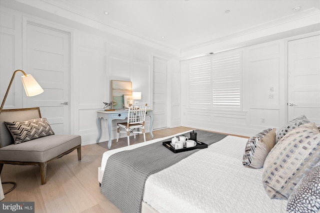 bedroom with light hardwood / wood-style flooring and ornamental molding