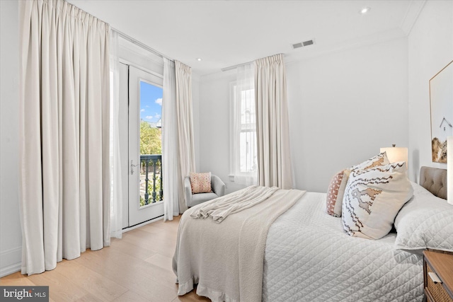 bedroom featuring access to outside, ornamental molding, and light hardwood / wood-style flooring