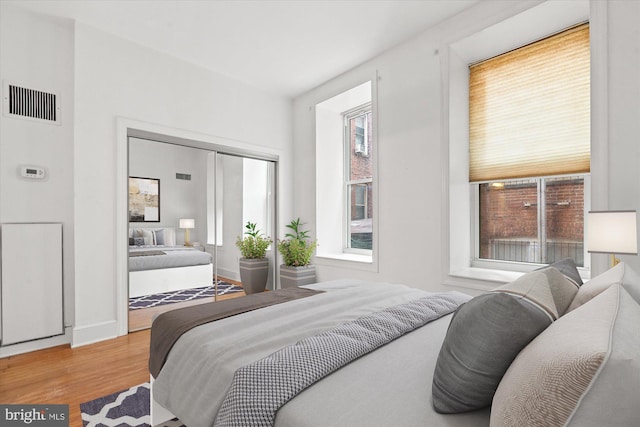 bedroom with light hardwood / wood-style flooring and multiple windows