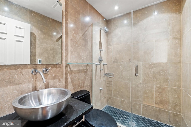 bathroom with tile walls, vanity, and an enclosed shower