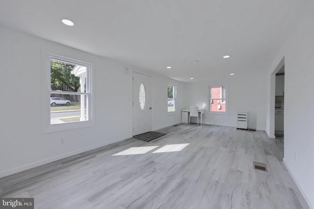 foyer entrance featuring light wood-type flooring and a wealth of natural light