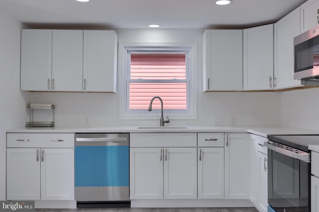 kitchen with light wood-type flooring, white cabinetry, sink, and stainless steel appliances