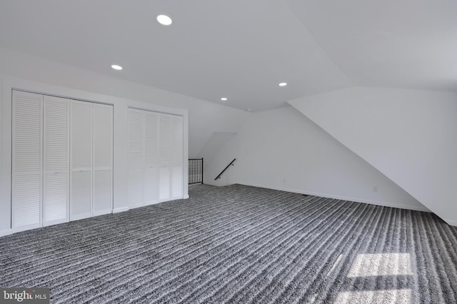 bonus room featuring dark carpet and vaulted ceiling