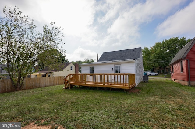 rear view of property with a deck and a yard