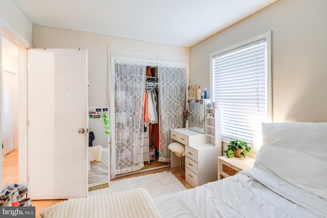 bedroom with light wood-type flooring and a closet