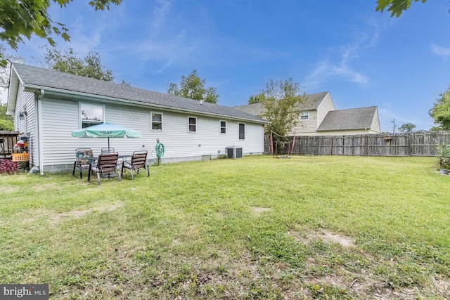 back of house featuring a yard and central AC