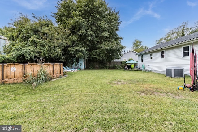 view of yard with central AC unit and a shed