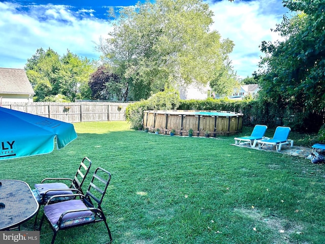 view of yard with a fenced in pool