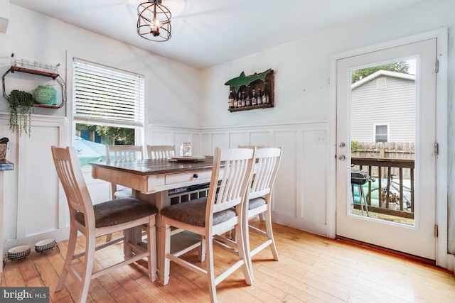 dining area featuring light wood-type flooring and a notable chandelier