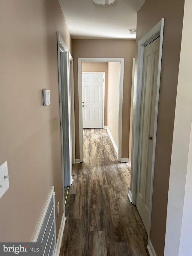 hallway with dark hardwood / wood-style flooring