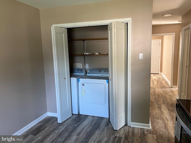 laundry area with dark wood-type flooring and washer and clothes dryer