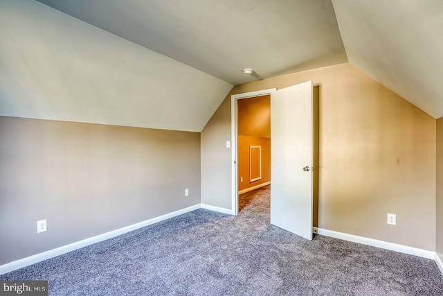 bonus room featuring vaulted ceiling and dark carpet