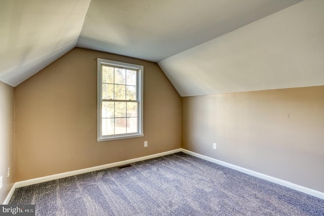 bonus room with vaulted ceiling and carpet flooring