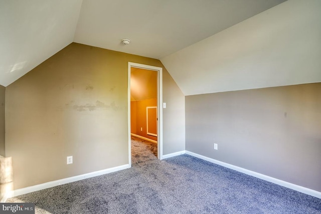 bonus room with carpet flooring and vaulted ceiling