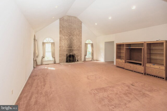 carpeted living room featuring a brick fireplace and vaulted ceiling