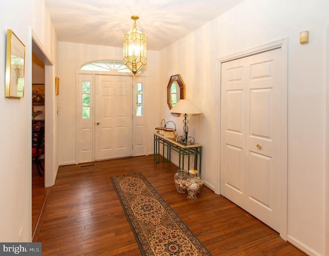 foyer with a notable chandelier and dark hardwood / wood-style floors