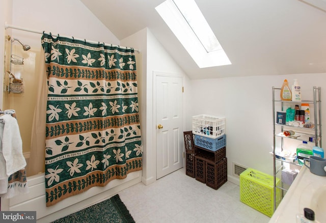 bathroom featuring vanity, vaulted ceiling with skylight, and shower / bath combo