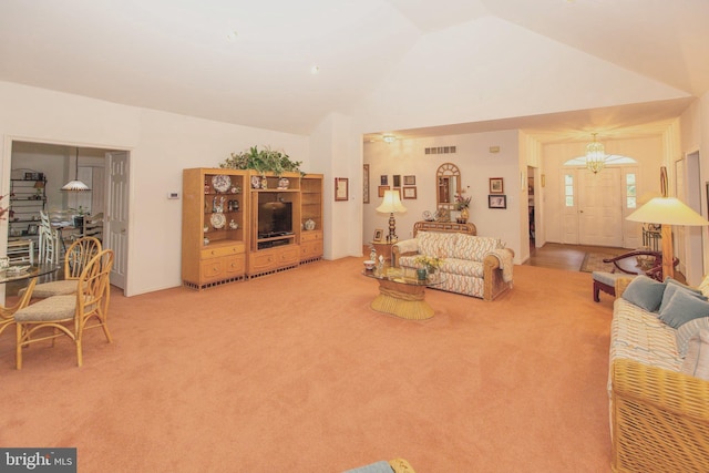 carpeted living room featuring a notable chandelier and lofted ceiling