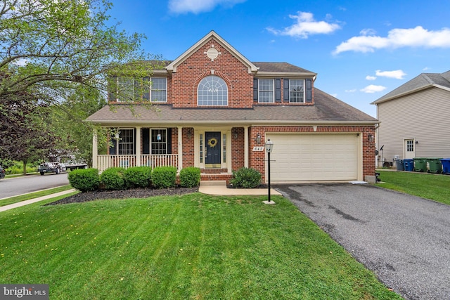 view of front of home with a porch, a garage, and a front lawn