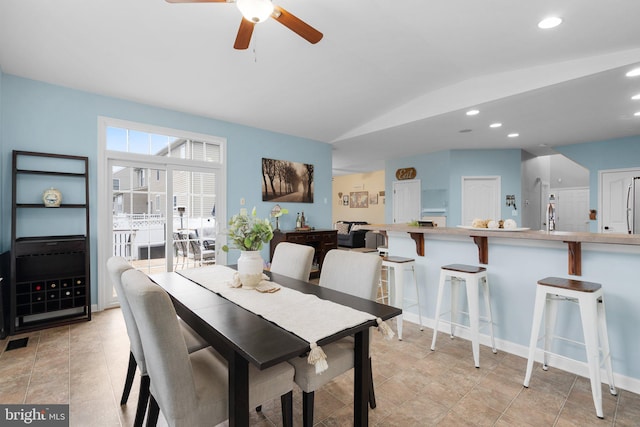 tiled dining space with vaulted ceiling and ceiling fan