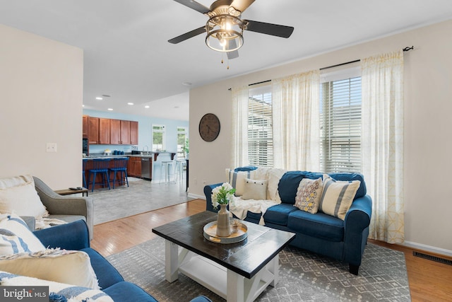 living room with hardwood / wood-style flooring, ceiling fan, and a wealth of natural light